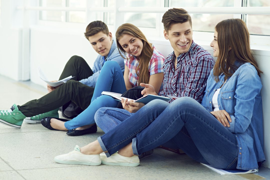 Teenager sitzen am Boden und sprechen mitenander